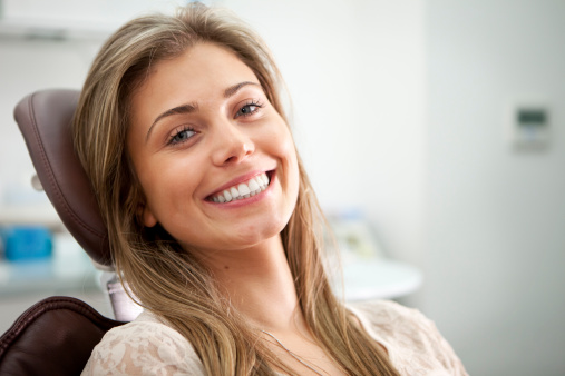 Woman sitting in a dentist chair and smiling